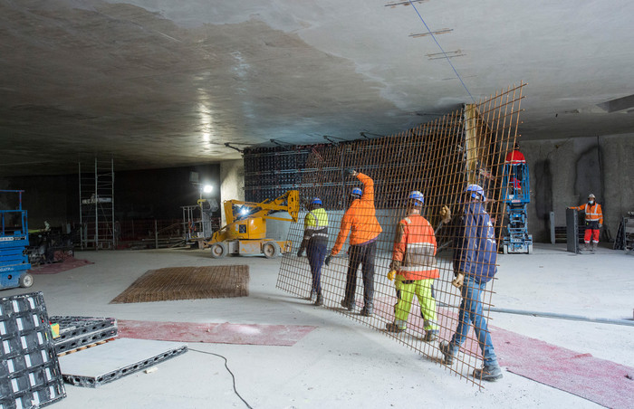 Des grilles métalliques sont installées pour construire la structure qui accueillera les ascenseurs.