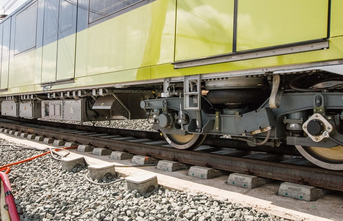 Roues d'un train sur une voie dans le cadre des essais de traverses du Grand Paris Express