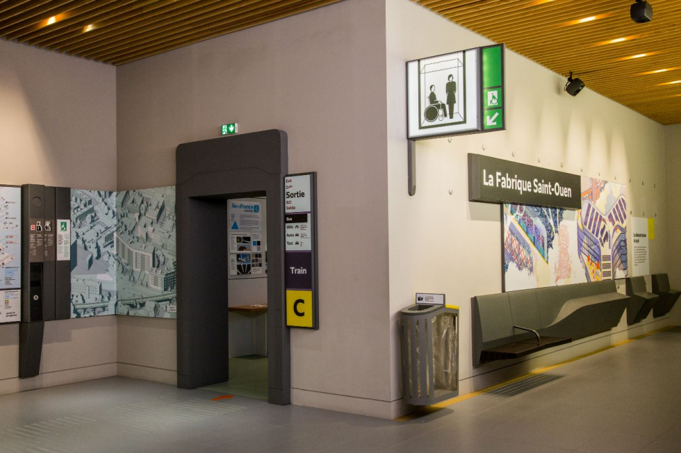 Station name with illustration, comfortable seating, waste bin, lighted information sign, and wall-mounted call points.