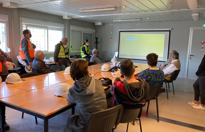 Ouvrage Sentier des Marins, dans la base vie des équipes de Colas Rails et Alstom, les riverains se préparent à la visite du chantier en assistant à une présentation du projet. 